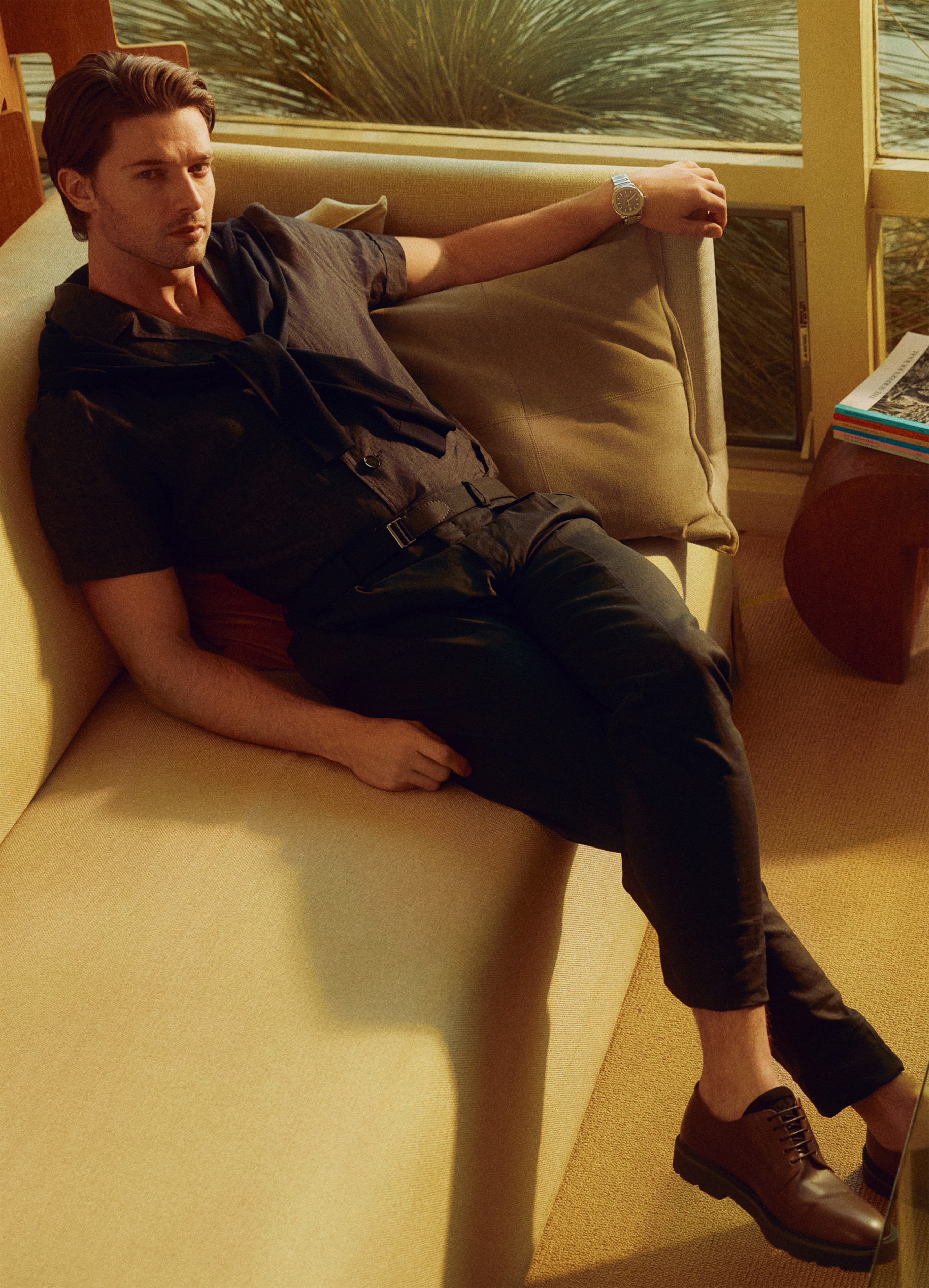 Patrick Schwarzneger in Brioni dark outfit, wearing wristwatch.